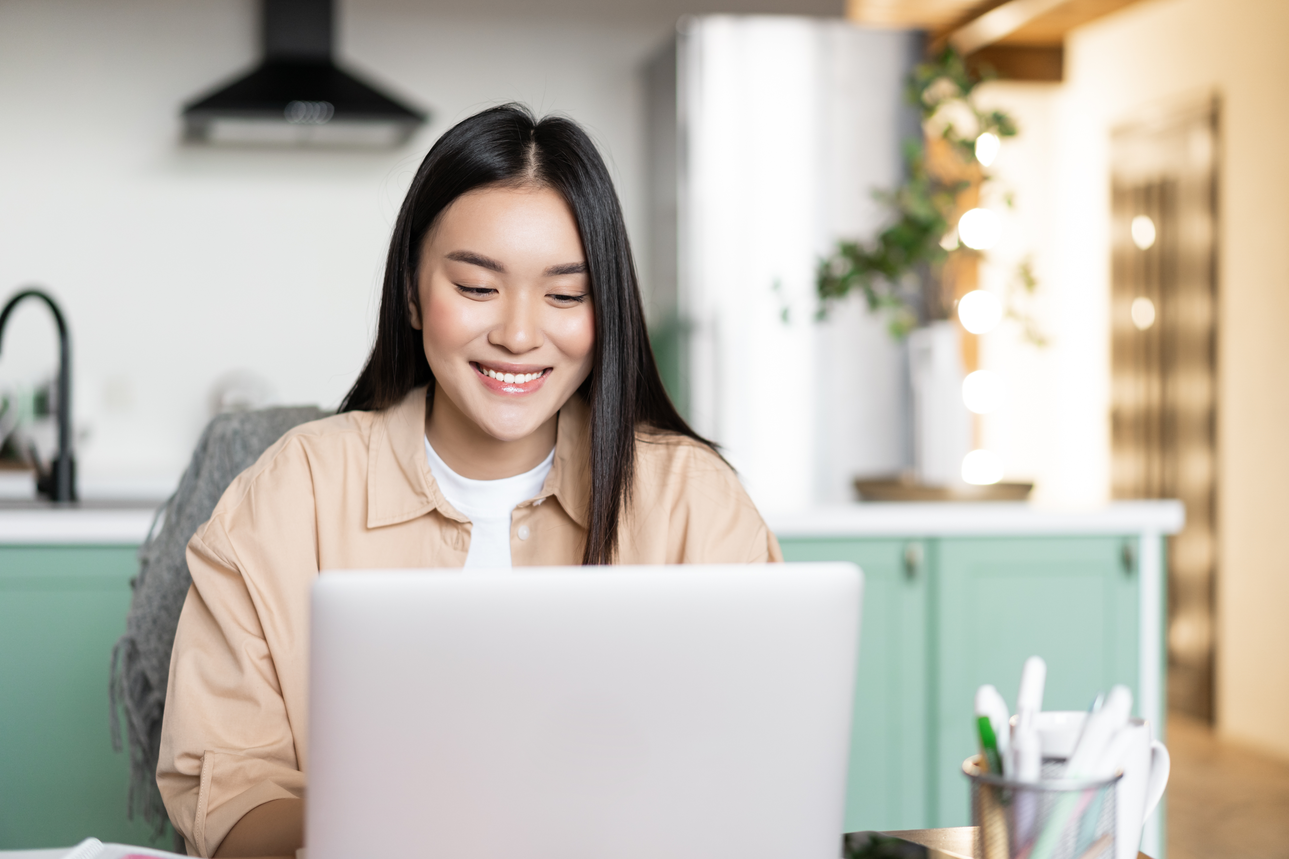 Woman smiling while working on a laptop